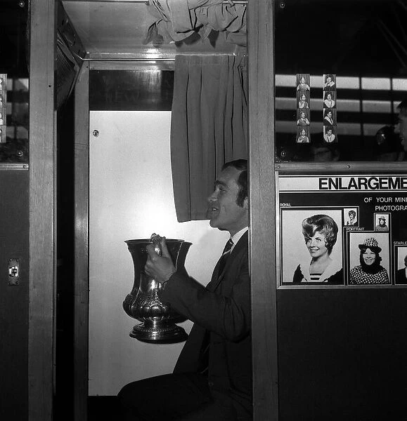 Chelsea captain Ron Harris sits in the Photo booth on Piccadilly station with the FA Cup