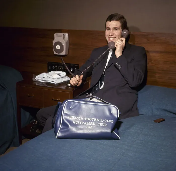 Framed Print : Chelsea footballer Peter Osgood on the telephone in his hotel room packing his bag Framed Print : Chelsea footballer Peter Osgood on the telephone in his hotel room packing his bag
