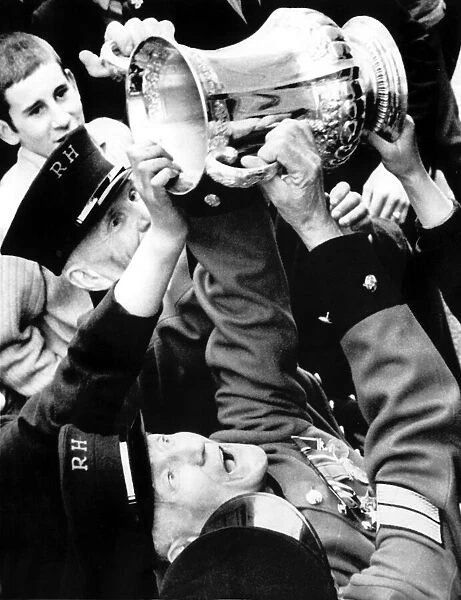 Chelsea Pensioners get a hand on the FA Cup as Dave Webb hands it to them during