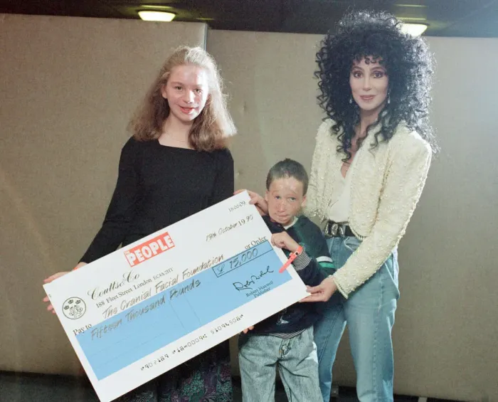 Framed Print : Cher, American singer, presents cheque for 15, 000 pounds to representatives of