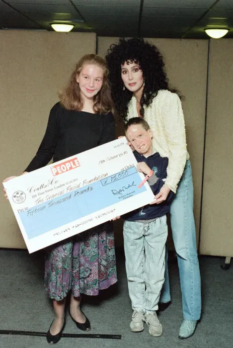 Framed Print : Cher, American singer, presents cheque for 15, 000 pounds to representatives of