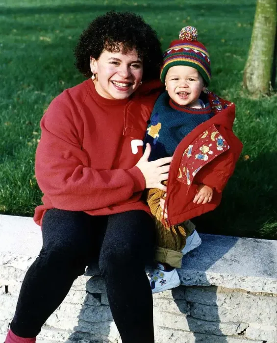 Framed Print : Cheryl Maker Actress who appears in TV soap Brookside sitting on wall with her son