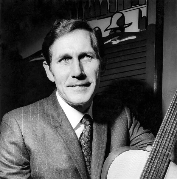 Chester Burton 'Chet'Atkins with a guitar he brought with him to present