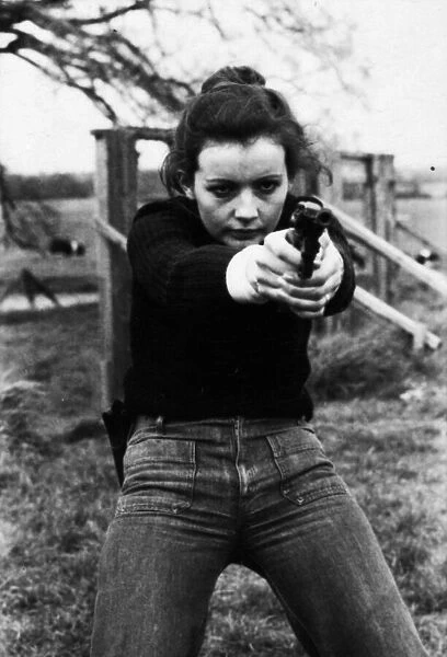Chief Instructor, Sergeant Ivor Montgomery, training police women on the firing range at