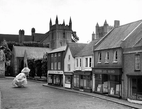A child looking at the shops at Wimborne Minster Model Town & Gardens. Dorset. Circa 1955