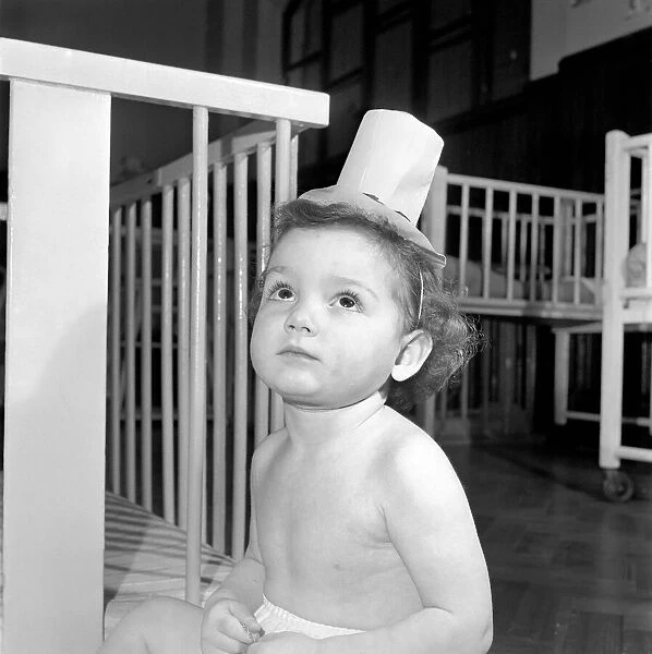 Child with teddy bear and toy top hat. December 1953 D7586