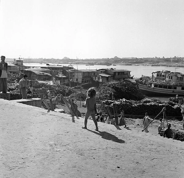 A child watches the boats unloaded in Dacca, Bangladesh. February 1961 l