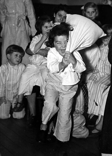 Children at bedtime have a pillow fight before bed. 23rd October 1950