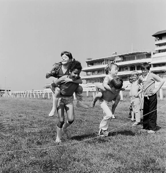 Children carrying their partners on their backs during a horse and jockey style egg