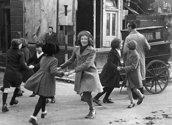 Children dance to the sound of a barrel organ in one of London