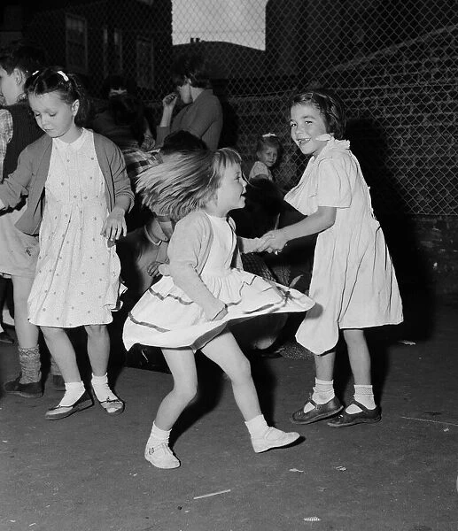 Children dancing to rock n roll music at a block of flats off Chapel Market