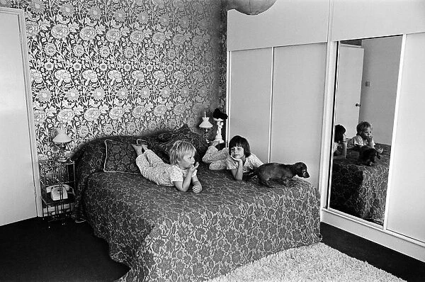 Two children and a dog on a bed in a display of a modern bedroom, 12th May 1969