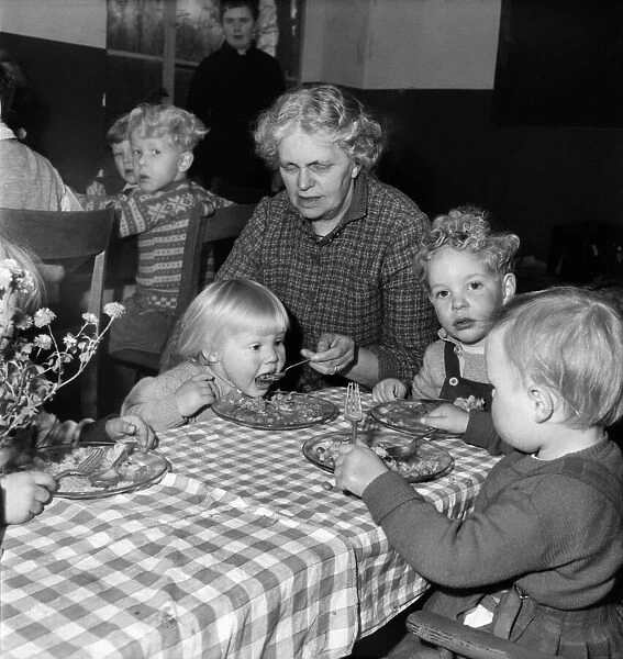 Children eating dinner at the table at a day nursery in Leeds November 1952