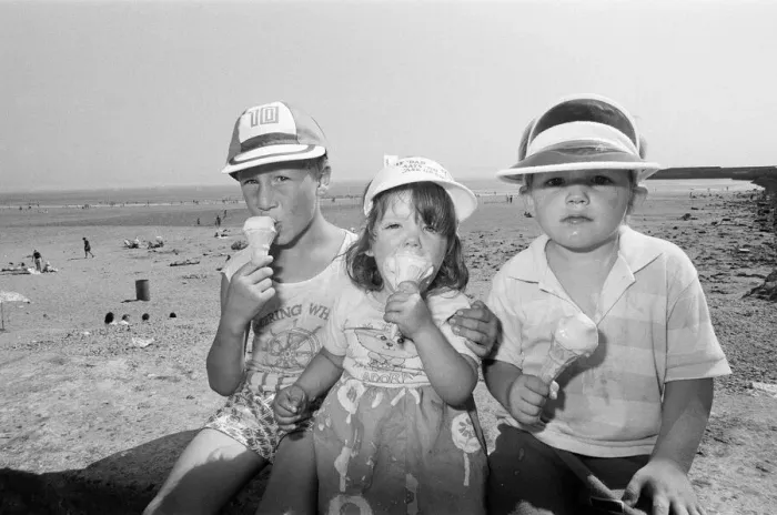 Framed Print : Children enjoy an ice cream as they try to keep cool on Coney Beach in Porthcawl