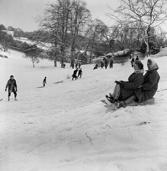 Why should the children only have fun, as two women take part in sledging in Stoke Park