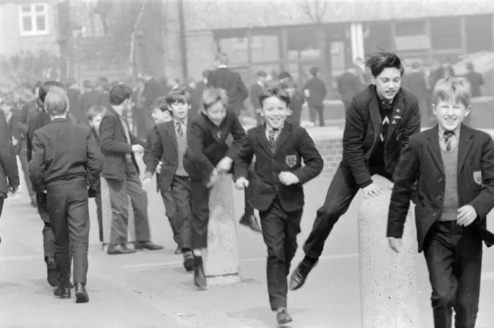 Framed Print : Children of a London Comprehensive school leap frogging over one of the concrete pillars
