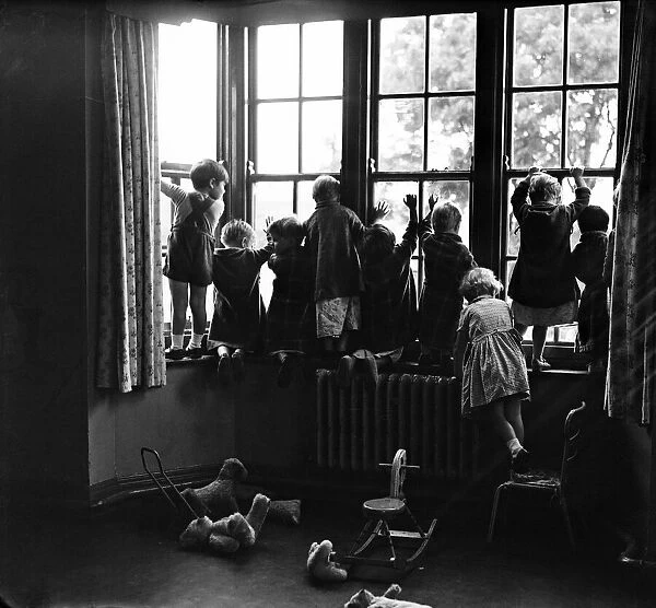 Children looking out of a window at a childrens home at South Shields