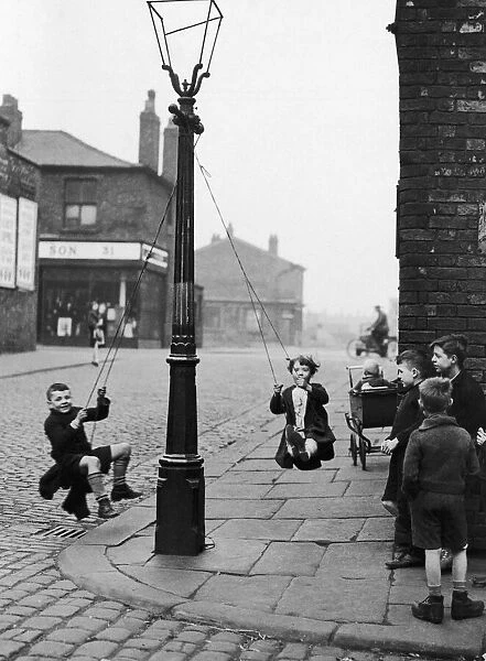 Children in a Manchester Street find their own enjoyment with the aid of a rope