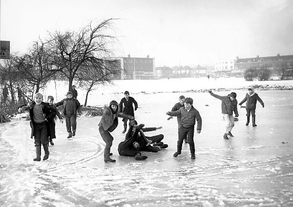 Children play on the ice formed on Quinton Pool, Cheylesmore, Coventry