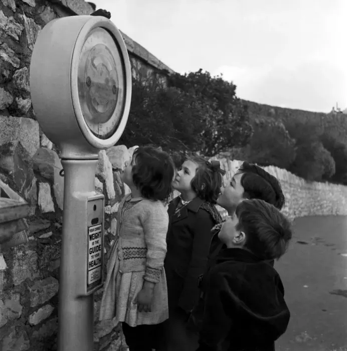 Framed Print : Children play on the weighing machine at Plymouth Promenade, Devon. 18th January 1954 Framed Print : Children play on the weighing machine at Plymouth Promenade, Devon. 18th January 1954