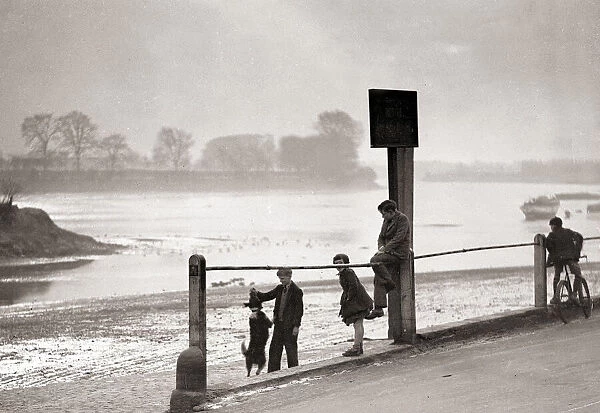 Children playing on the banks of the River Thames, Chiswick, London