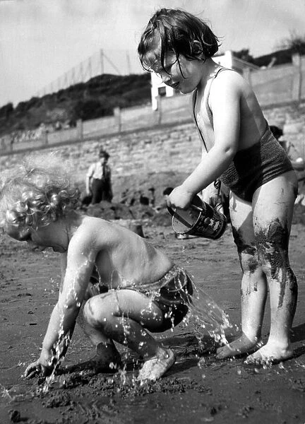 Two children playing on the beach on holiday. 2nd May 1952