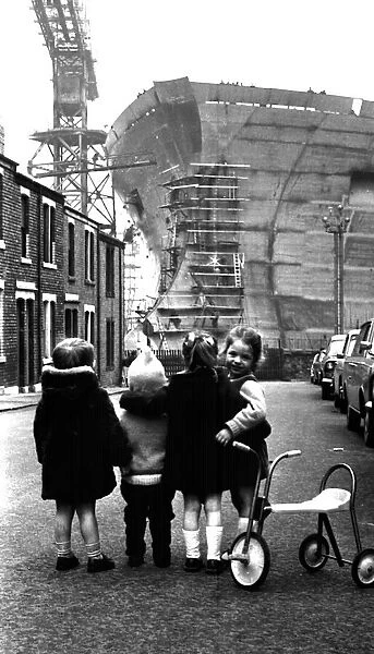 Children playing in the shadow of the giant 253, 000-ton oil tanker Esso Northumbria which