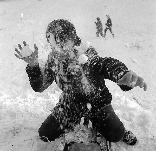 Children playing in the snow on Hampstead Heath. A small boy get hit in the face with a