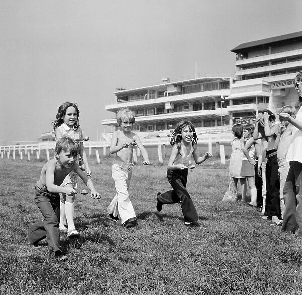 Children race across the finish line of the egg and spoon race on the Downs at Epsom