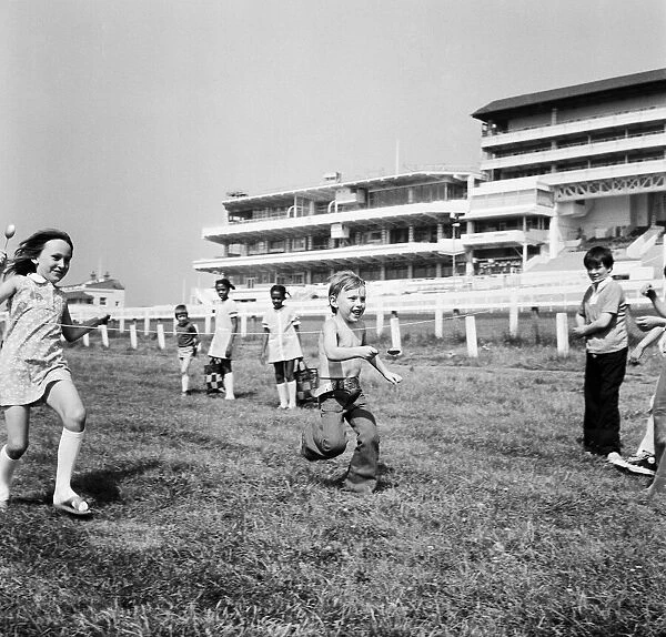 Children race across the finish line of the egg and spoon race on the Downs at Epsom