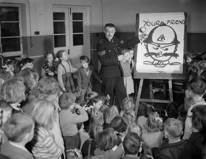 Framed Print : Children receiving a road safety lesson from a policeman during a class at school Framed Print : Children receiving a road safety lesson from a policeman during a class at school