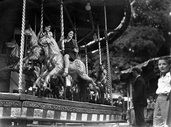 Children ride the Merry-Go-Round at the Surbiton fair. Circa 1930