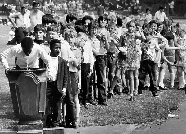 Children from St. Thomas Primary School queuing at a fountain. 9th July 1971