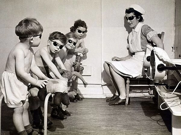 Children undergoing sunray treatment along with their dolls