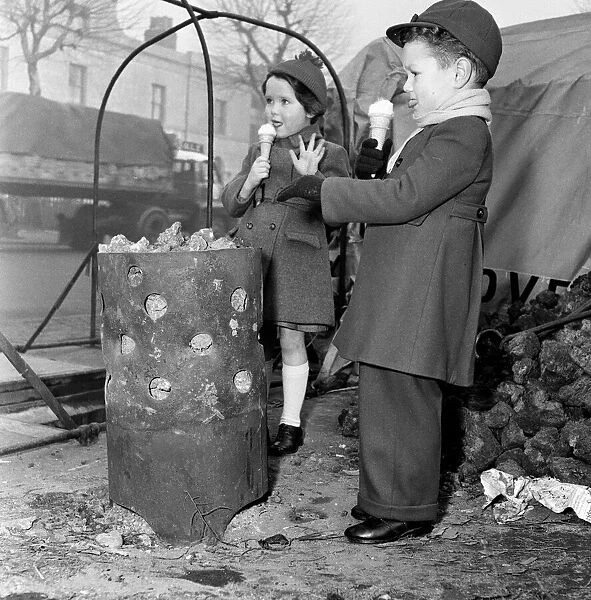 Children warming themselves round the watchmans fire. 5th January 1956