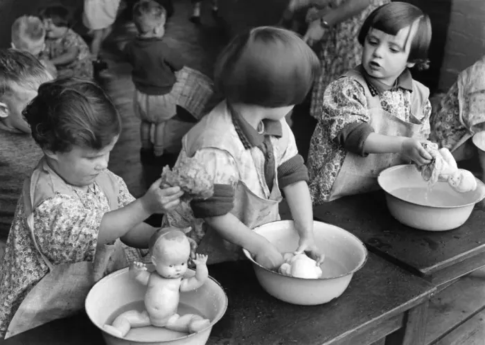Framed Print : Children washing their dolls in a small tin bath during a nursery class in Northfields