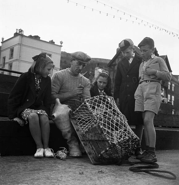 Children watching a fisherman at work with his net. North Yorkshire coast