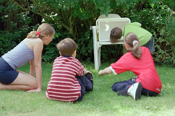 Children watching the solar eclipse indirectly at Hightown. 11th August 1999