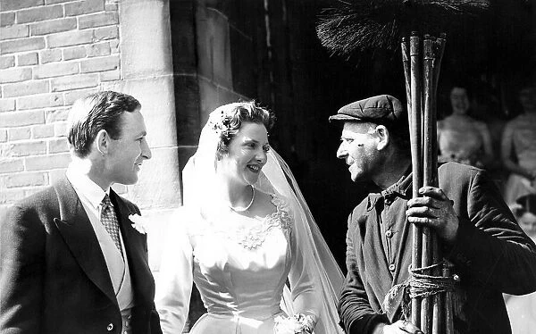 A chimney sweep wishing the bride good luck at her wedding. circa 1960