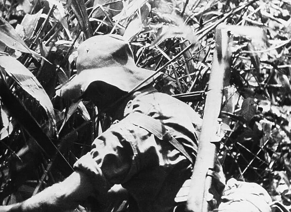 A Chindit hacks his way through thick jungle. A scene from the Army film Unit Production