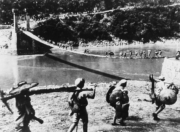 Chinese troops cross a temporary suspension bridge over the Salween river as they