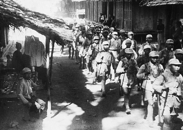 Chinese troops enter a Burmese village during Second World War. Circa March 1945