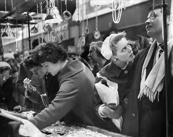 Christmas shoppers in Petticoat Lane, some carrying children others a parcel or a two