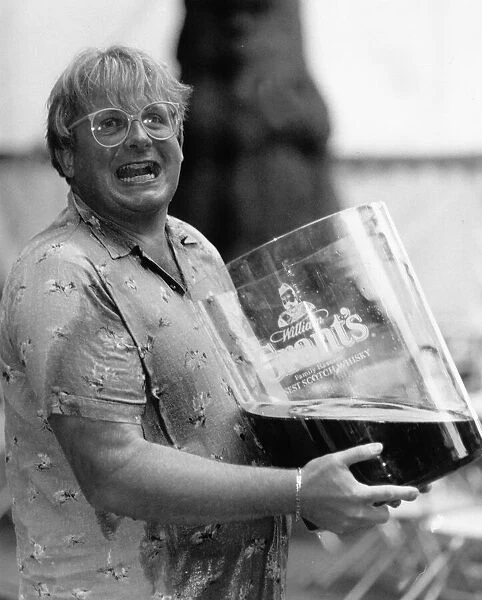Christopher Biggins with giant glass of Grants Whisky 1989