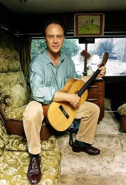 Christopher Cazenove actor sitting in his motor home playing guitar