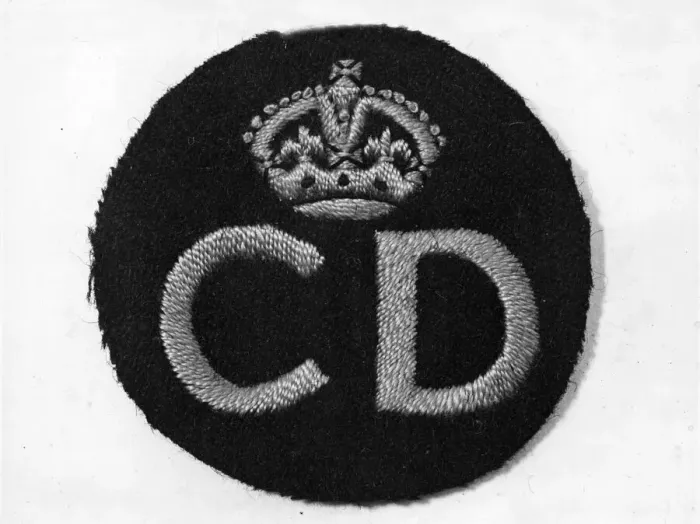 Framed Print : Civil Defence service badge, woven in a gold colour, worn on the left breast of a uniform Framed Print : Civil Defence service badge, woven in a gold colour, worn on the left breast of a uniform