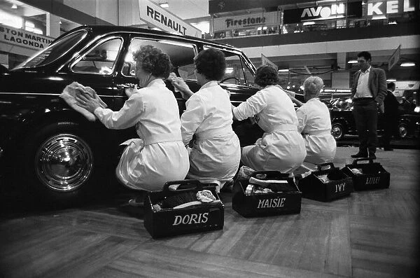 Four cleaning ladies polishing up one of the motors at the Earls Court Motor show
