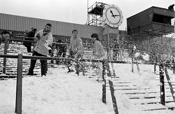 Clearing snow of the terraces at Highbury Stadium, home ground of Arsenal Football Club