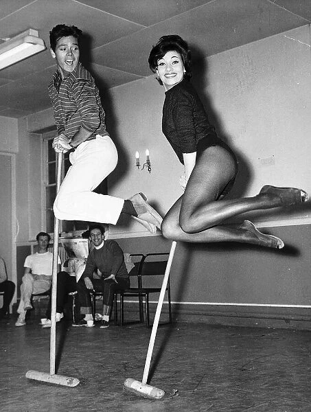 Cliff Richard Actor  /  Singer with Carole Gray dancing with broom sticks