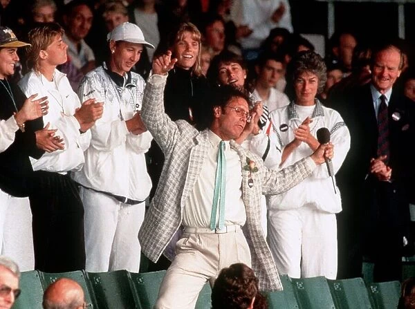 Cliff Richard entertains the tennis fans during a break in play due to the weather